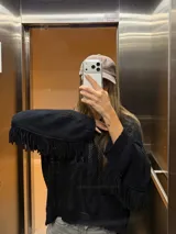 Buzo con capucha de tejido de punto abierto, color blanco roto, de corte oversize y manga larga con detalle de flecos en los puños.