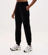 Pantalón tipo jogger de plush color negro, con cintura elástica, bolsillos laterales y puños ajustados en los tobillos.