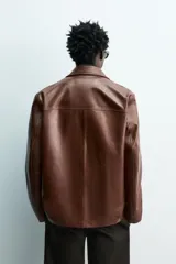 Blazer de corte relajado confeccionada en piel napada, con cuello de solapas de muesca, manga larga y cierre frontal de tres botones. Presenta bolsillos con solapa en la parte delantera.