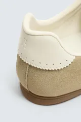 Zapatilla de cordones de estilo retro, con parte superior de serraje color bordó y detalles en piel lisa color rojo. Suela ultrafina de goma en tono marrón oscuro.