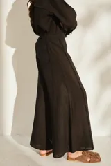Pantalón ancho negro de lino con cintura elástica y detalles de flecos en los laterales.