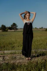 Conjunto de dos piezas compuesto por un top sin mangas con diseño bicolor en blanco y negro y detalle bordado frontal, y un pantalón de corte recto y ancho en color negro con bolsillos laterales y cintura ajustable.