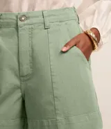 Short regular de talle alto confeccionado en sarga de color marrón, con trabillas para cinturón, cierre con botón y cremallera, bolsillos delanteros y traseros, y pespuntes en contraste.