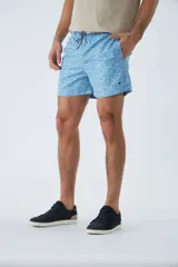 Short de baño con estampado de líneas curvas en tonos azules, cintura elástica con cordón ajustable, bolsillos laterales y bolsillo trasero. Incluye suspensor interno y logo bordado.