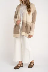 Cardigan abierto de punto con diseño de bloques de color en tonos beige, marrón y bordó. Presenta mangas largas, corte recto y bolsillos frontales aplicados.