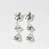 Par de caravanas colgantes plateadas con tres dijes irregulares.