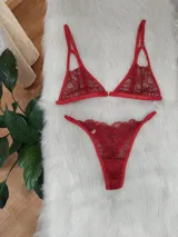 Conjunto de lencería compuesto por un corpiño triangular de encaje con tirantes finos y una bombacha tipo colaless de encaje a juego.