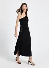 Vestido midi negro de punto, con un solo hombro, detalle de nudo en el hombro y botones metálicos decorativos en el lateral.