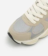 Championes de running Viko con diseño de paneles superpuestos en tonos gris y plateado. Presentan una combinación de malla técnica y detalles sintéticos, con suela de plataforma robusta y cierre mediante cordones.