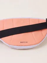 Riñonera negra de poliéster con correa ajustable y logo de la marca Rusty estampado en blanco.