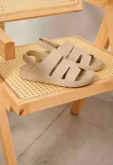 Sandalias de gamuza color beige con tiras anchas, aberturas laterales y tira en el talón con cierre ajustable.