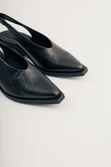Zapato slingback negro con textura de piel de cocodrilo, punta fina y tacón bloque bajo.