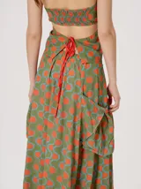 Falda midi de tiro alto y silueta evasé, confeccionada en algodón con diseño estampado geométrico en tonos verdes, naranjas y celestes. Cuenta con caída fluida, ruedo ligeramente acampanado y dos bolsillos cuadrados laterales.