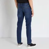 Jean slim de hombre color azul, con cierre de botón y cremallera, y bolsillos delanteros y traseros.