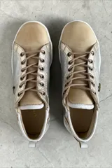 Championes de cuero de diseño artesanal, combinados en tonos plateado, dorado y natural. Presentan detalles pintados a mano por Carolina De Cunto, cordones al tono, suela de goma blanca y aplique metálico con logo en el lateral.
