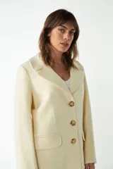 Tapado largo color beige confeccionado en lana, con cuello con solapa, manga larga, forrado, con bolsillos y cierre frontal con botones. Tela 100% lana fina sin teñir, diseñada exclusivamente por Don Baez. Hecho 100% en Uruguay.