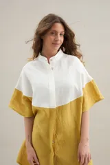 Camisa larga de lino con diseño bicolor en tonos beige y marrón, cuello mao y mangas cortas.