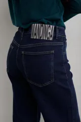Pantalón de jean negro de corte recto y tiro medio, con cierre frontal de botón y cremallera, y bolsillos laterales y traseros.