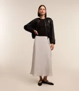 Pollera midi evasé de poliéster, color gris claro, con textura satinada y corte fluido.