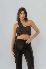 Top negro de un solo hombro con frunces y lazo lateral.