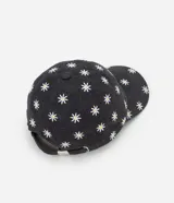 Gorra de sarga de algodón con visera curva y ajuste trasero. Presenta un estampado integral de margaritas blancas sobre fondo gris oscuro.