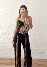 Top corto con estampado animal print en tonos verde y negro, con detalles de encaje negro en el escote y ruedo.