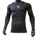 Remera térmica de manga larga para hombre, diseñada con un ajuste ceñido al cuerpo. Presenta cuello redondo y un logo minimalista estampado en el centro del pecho. Confeccionada en tejido técnico de secado rápido.
