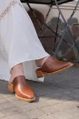 Zuecos de cuero color marrón con punta fina y taco de madera.