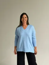 Sweater de punto color celeste, con cuello en V, mangas largas con puños acanalados y detalle de costura vertical central.