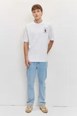 Remera blanca de algodón con cuello redondo, manga corta y pequeño estampado en el pecho.