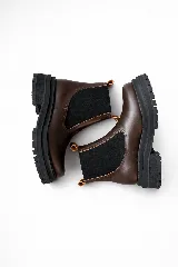 Botas tipo Chelsea de cuero color marrón con paneles elásticos laterales negros y suela track de goma negra con plataforma.