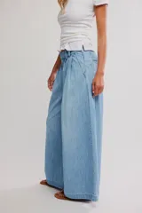 Pantalón de denim celeste de tiro bajo, pierna muy ancha y diseño sastrero con tablas al frente. Cuenta con cintura fruncida en la espalda, bolsillos y cierre frontal con cremallera y gancho.
