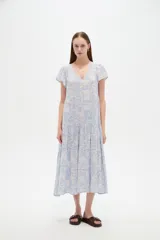 Vestido midi de viscosa con estampado floral en tonos celeste y blanco, cuello en V, mangas cortas y diseño holgado con volados escalonados en la falda.