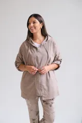 Campera tipo parka liviana color visón, con cierre frontal, capucha con cordones ajustables y mangas 3/4 con detalle de trabilla. Presenta un diseño holgado y casual.
