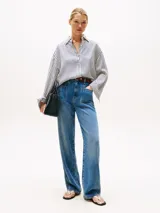 Camisa oversize de manga larga con cuello clásico y puños abotonados. Diseño a rayas verticales en blanco y azul marino.