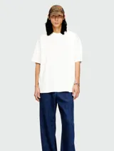 Remera blanca de manga corta, cuello redondo y corte holgado.