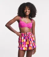 Short de playa con cintura elástica y lazo decorativo. Estampado de lunares grandes en tonos rosa, naranja, amarillo, blanco y violeta.