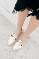 Mocasines dorados de cuero ovino con apliques de strass y piedras negras.