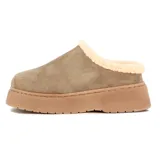 Pantuflas tipo sueco de gamuza color taupe, con interior forrado en corderito sintético color crema y plataforma de goma al tono. Presenta el logo de la marca bordado en el lateral.