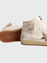 Botines de caña alta color blanco con detalles en dorado, cordones color crema y suela color caramelo.