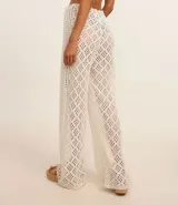 Pantalón de playa tejido al crochet color blanco, con cintura elastizada con lazo y borlas.