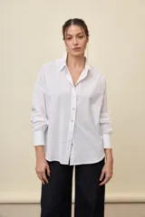 Camisa celeste de corte oversize, con mangas largas, cuello camisero y cierre frontal de botones.