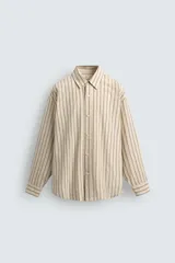 Camisa de algodón de corte relajado, color beige con finas rayas verticales en tonos gris y amarillo. Presenta cuello solapa, manga larga con puños abotonados y bajo con aberturas laterales.