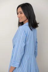 Vestido midi cruzado de seda con estampado de rayas celestes y blancas, escote en V con solapa, mangas tres cuartos y detalle de nudo drapeado en la cintura.
