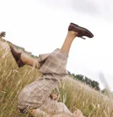 Mocasín de cuero color óxido con costuras rojas.