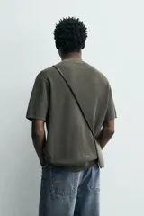 Camiseta de punto de algodón con textura perlada, corte regular fit, cuello redondo y manga corta con terminaciones en rib.