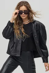 Chaqueta de cuero negro con diseño oversized, hombros estructurados y apliques geométricos en el pecho.