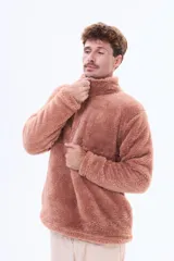 Buzo de sherpa de textura suave y cálida, con cuello alto y cierre frontal parcial. Presenta un diseño de manga larga y corte holgado.