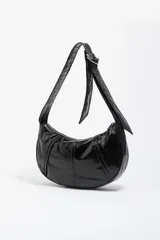 Bolso de hombro de tamaño pequeño con estructura blanda, confeccionado en material sintético con acabado brillante efecto charol. Presenta cierre de cremallera, asa ajustable con detalle de hebilla metálica y logo de la marca en la parte frontal.