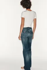 Jeans de tiro bajo y diseño bootcut, con efecto lavado, trabillas y cinco bolsillos clásicos. Cuenta con cierre frontal de cremallera y botón metálico.